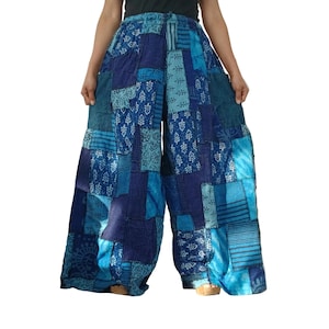 Könnte beinhalten: Weit geschnittene Hose mit Patchwork-Design in verschiedenen Blautönen. Der Stoff zeigt eine Mischung aus Mustern, darunter florale Motive, Streifen und geometrische Formen, die aus mehreren rechteckigen Stoffbahnen zusammengesetzt sind.