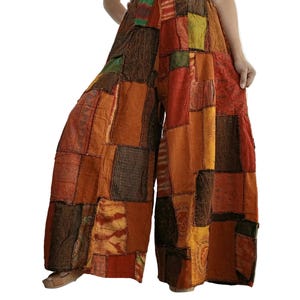 Könnte beinhalten: Weit geschnittene Hose mit Patchwork-Design in verschiedenen Orange-, Braun- und Grüntönen. Das Kleidungsstück verfügt über einen elastischen Bund mit Kordelzug und besteht aus mehreren Stoffbahnen mit unterschiedlichen Texturen und Mustern.
