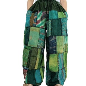 Könnte beinhalten: Weit geschnittene Hose mit Patchwork-Design in verschiedenen Grüntönen. Das Kleidungsstück verfügt über einen elastischen Bund mit Kordelzug und besteht aus mehreren rechteckigen Stoffbahnen mit unterschiedlichen Mustern und Texturen.