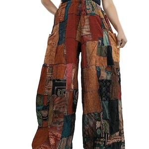 Könnte beinhalten: Weit geschnittene Hose mit Patchwork-Design aus verschiedenen Stoffquadraten in Rost-, Braun-, Schwarz- und Petroltönen. Die Hose verfügt über einen elastischen Bund mit Kordelzug, Seitentaschen und eine lockere, fließende Passform mit Mustern.