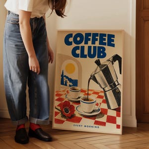 May include: A rectangular framed poster featuring the text COFFEE CLUB and EVERY MORNING. The illustration depicts a moka pot pouring coffee into a white cup on a red and white checkered tablecloth, with a second cup and a red flower nearby.