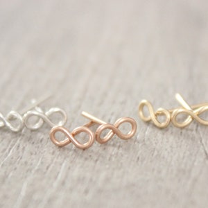 May include: Three pairs of infinity symbol earrings in silver, rose gold, and gold.