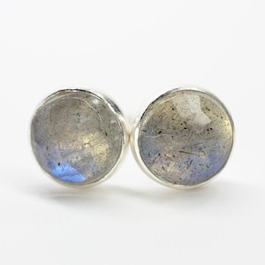 May include: A pair of silver stud earrings with round, iridescent labradorite gemstones.