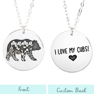 May include: Silver necklace with a round pendant featuring a black bear silhouette with the word "mama" and floral details on the front. The back of the pendant has the text "I LOVE MY CUBS!" with a small heart.