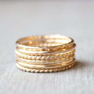 Set of 6 14 karat gold filled rings. 2 smooth bands, 2 hammered bands and 2 twist bands. Each ring is 1.3 millimeters thick