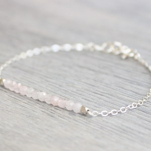 Op de afbeelding: Een delicate zilveren kettingarmband met een rij lichtroze rozenkwarts kralen.