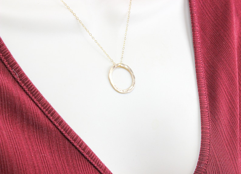 May include: A gold chain necklace with a hammered circle pendant.