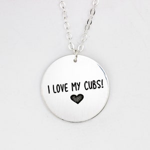 May include: Silver necklace with a round pendant that says "I love my Cubs!" with a small heart below the text.