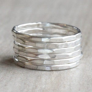 May include: A set of six silver hammered stacking rings. The rings are all the same width and have a textured surface.