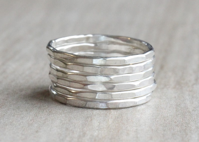 May include: A set of six silver hammered stacking rings. The rings are all the same width and have a textured surface.