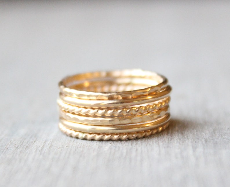 Set of 6 14 karat gold filled rings. 2 smooth bands, 2 hammered bands and 2 twist bands. Each ring is 1.3 millimeters thick