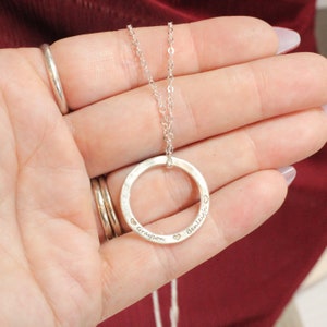 May include: Silver necklace with a circle pendant engraved with the names "Grayson" and "Bentleigh" and small heart symbols.
