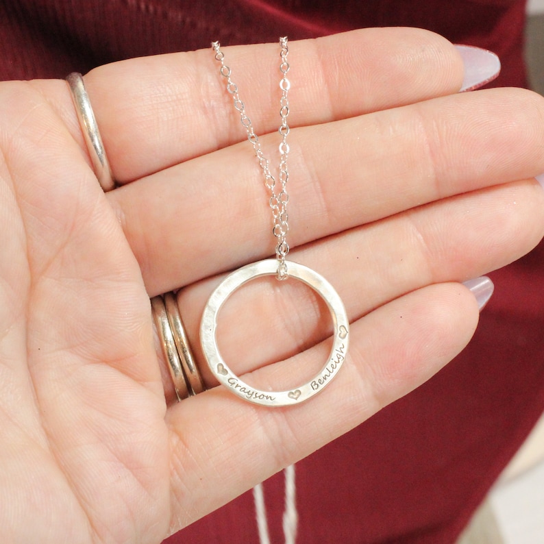 May include: Silver necklace with a circle pendant engraved with the names "Grayson" and "Bentleigh" and small heart symbols.