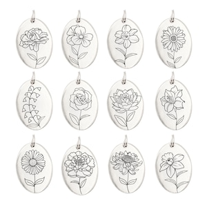 May include: A collection of twelve oval-shaped pendants, each featuring a different floral design. The pendants are silver-colored and have a small loop at the top for a chain. The floral illustrations are detailed line drawings of various flowers.