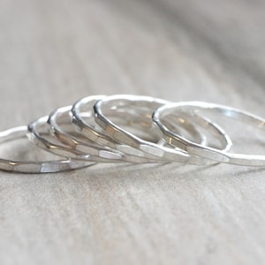 May include: A set of five silver hammered stacking rings. The rings are all different sizes and are stacked on top of each other.