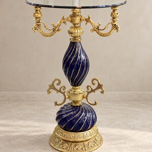 Mesita auxiliar de cristal ornamentada en azul cobalto y dorado con pedestal escultural.