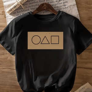 Women&#39;s Casual Black T-Shirt with Iconic Circle, Triangle, and Square Design – Show Inspired Graphic Tee