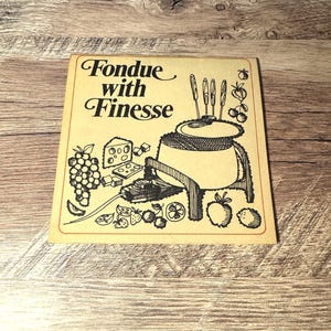 May include: A vintage cream-coloured card with the words "Fondue with Finesse" in elegant script. The illustration features a fondue pot, fruit, cheese, and fondue forks, all in black and white line art. The card has a red border.