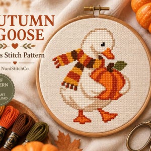 May include: A cross stitch pattern in a wooden hoop featuring a white goose wearing a striped orange, yellow, and brown scarf while holding an orange pumpkin. The text reads AUTUMN GOOSE Cross Stitch Pattern, NuniStitchCo, and PDF PATTERN INSTANT DOWNLOAD.