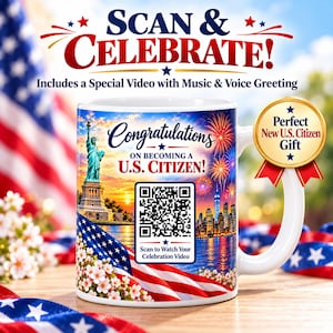 May include: A white ceramic mug featuring a graphic of the Statue of Liberty, a city skyline, fireworks, and an American flag. The text reads: Congratulations ON BECOMING A U.S. CITIZEN! A QR code is centered with the text: Scan to Watch Your Celebration Video.