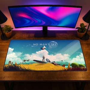 May include: A rectangular desk mat featuring a No Man's Sky Beyond 2.0 graphic print. The artwork displays a yellow grassy landscape, a landed spacecraft, a standing figure, and a blue sky with clouds, planets, and a floating geometric structure.