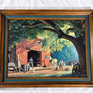 May include: A framed print by Paul Detlefsen depicting a brick blacksmith shop under a large tree. The scene features a white horse, a blacksmith at an anvil, and figures in a yard. A sign above the shop entrance reads Blacksmith Shop.