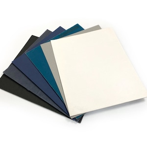 May include: A set of six sheets of sandpaper in various shades of blue, gray, and black. The sheets are arranged in a fan shape, with the lightest sheet on top.