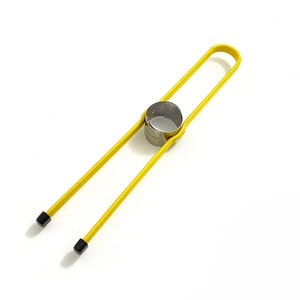 May include: A yellow metal apple corer with black rubber ends. The corer has a round, stainless steel cutter in the middle.