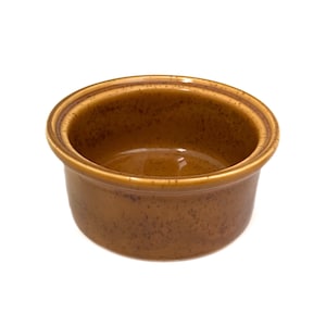 May include: A small, round, brown ceramic bowl with a slightly flared rim. The bowl has a speckled texture and a glossy interior, suitable for serving dips or small portions. The exterior is a warm, earthy tone.