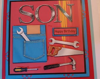 May include: A square greeting card with a red background featuring the word SON in large silver letters. It displays a blue denim pocket with a wrench, a hand saw, a hammer, a screwdriver, and a sign that reads Happy Birthday.