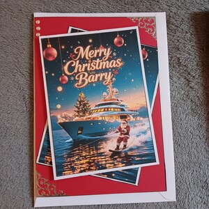 May include: A rectangular greeting card with a red border and gold corner accents. The center image features a yacht on water with a Christmas tree on deck, Santa Claus water skiing, and the text Merry Christmas Barry in gold script.