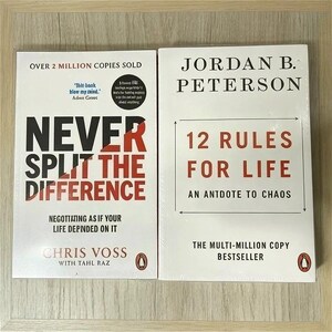 Op de afbeelding: Twee paperbacks naast elkaar. Het linkerboek is getiteld Never Split the Difference van Chris Voss met Tahl Raz, met zwarte en rode tekst op een witte kaft. Het rechterboek is 12 Rules for Life van Jordan B. Peterson met zwarte en rode tekst.