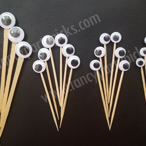 May include: Assortment of googly eyes on wooden skewers. The eyes are various sizes and come in white with black pupils. There are 18 googly eyes in total.