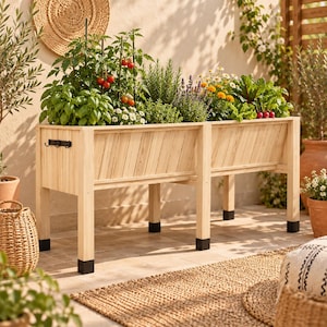 Op de afbeelding: Een rechthoekige verhoogde plantenbak van lichtgekleurd hout met diagonale lattenpanelen, ondersteund door vier poten met zwarte beschermvoetjes. De plantenbak is voorzien van een kleine zwarte metalen haakjesrail aan de zijkant.