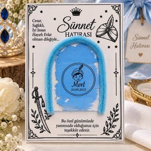 May include: A rectangular white card featuring black decorative borders, a crown, a turban, and a sword illustration. The card displays the text Sünnet HATIRASI, Mert, 20.09.2025, and Turkish phrases. A light blue fuzzy arch is centered over a blue paint stroke.