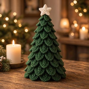 May include: A dark green crocheted Christmas tree decoration featuring layered, leaf-shaped stitches and a small, cream-colored crocheted star topper. The tree has a conical shape and is constructed with a textured, yarn-based design.