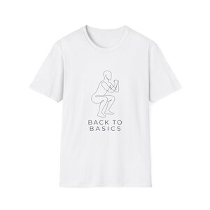 May include: A white short-sleeved t-shirt featuring a black single-line drawing of a person performing a squat exercise. Below the graphic, the text BACK TO BASICS is printed in a clean, sans-serif black font centered on the chest area.