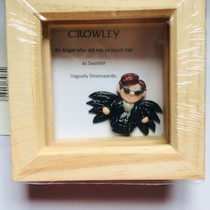 Dobre znaki zainspirowały Crowleya, Aziraphale'a, obie oprawione w ramę miniaturowe figurki z gliny polimerowej i cytat