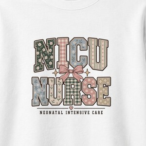 May include: A white sweatshirt featuring the text NICU NURSE in block letters with various floral, gingham, and striped patterns in muted tones. A pink bow sits between the words, and the text NEONATAL INTENSIVE CARE appears below.