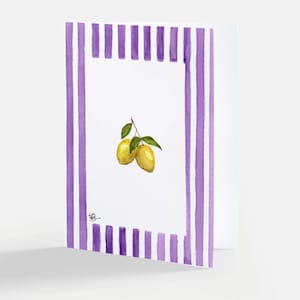 Peut inclure: Une carte de vœux pliée présentant une illustration à l'aquarelle de deux citrons jaunes avec des feuilles vertes centrée sur un fond blanc, encadrée par une bordure de rayures verticales violettes. Une petite signature noire est visible.