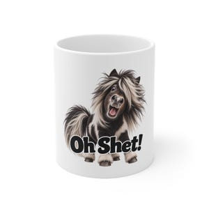 May include: A white ceramic mug featuring a graphic of a black and white Shetland pony with a long, shaggy mane and an open-mouthed expression. Below the pony, the text "Oh Shet!" is printed in bold, black, sans-serif capital letters.