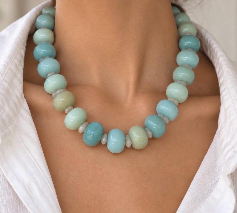 The Palm Beach necklace worn with a white shirt: large round blue quartz and white moonstone beads, with small pale spacers between them.