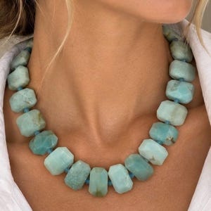 The Santorini necklace worn with a white shirt: chunky blue-green amazonite and aquamarine beads with small gold-colored spacers.