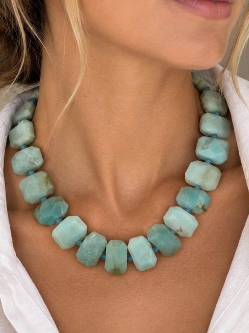 The Santorini necklace worn with a white shirt: chunky blue-green amazonite and aquamarine beads with small gold-colored spacers.