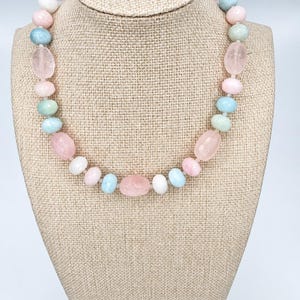 The Bellamy necklace on a beige linen display bust: rose quartz nuggets with round morganite and moonstone beads in blush pink, soft aqua and creamy white.