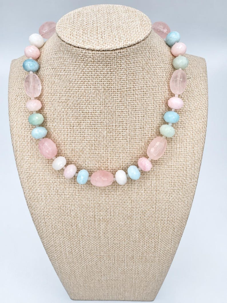 The Bellamy necklace on a beige linen display bust: rose quartz nuggets with round morganite and moonstone beads in blush pink, soft aqua and creamy white.