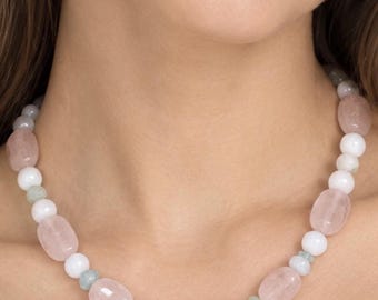 Peut inclure: Un collier de perles composé d'un motif répétitif de pierres ovales rose pâle translucides et polies, de perles sphériques blanches opaques et lisses, et de petites entretoises cylindriques vert pâle disposées en cercle.