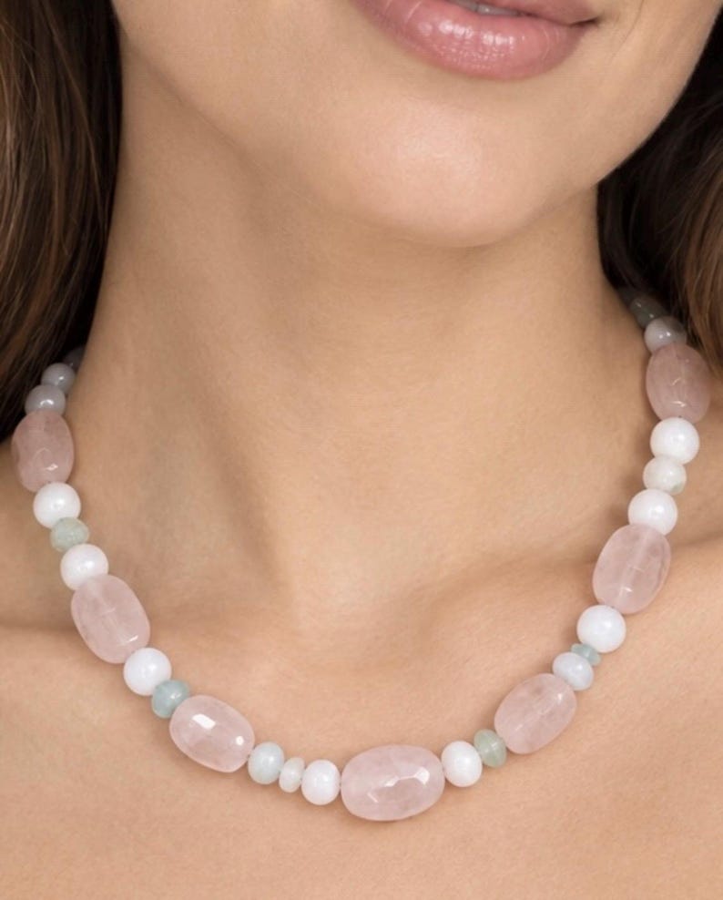 The Camille necklace worn at the collarbone: pale pink rose quartz ovals, round white beads and small pale green spacers.