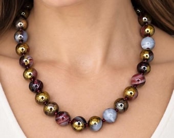 May include: A beaded necklace featuring a repeating pattern of round, polished beads in metallic gold, translucent light blue, and dark maroon with white swirling striations, all strung together on a thin cord with small dark spacers between each bead.