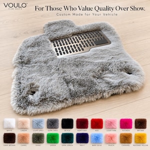 Puede incluir: Una alfombrilla de coche de piel sintética gris con una almohadilla metálica para el talón con patrón de rejilla. El texto dice: VOULO CAR MATS, For Those Who Value Quality Over Show. Custom Made for Your Vehicle. Veinte muestras de color con etiquetas.